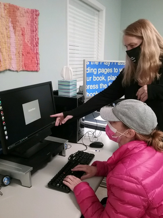 A women in black clothing with blonde hair helping another woman in pink utilize ZOOM Tech.